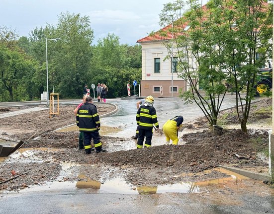 Hasiči odčerpávají vodu ze  silnice