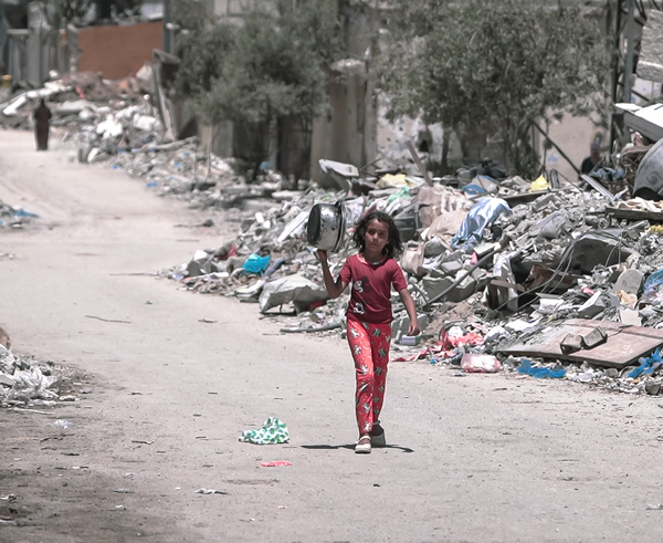 A_girl_walks_inside_Gaza_during_the_Gaza-Israel_war_to_get_food