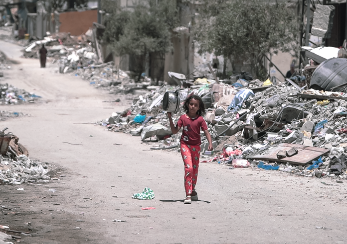 A_girl_walks_inside_Gaza_during_the_Gaza-Israel_war_to_get_food