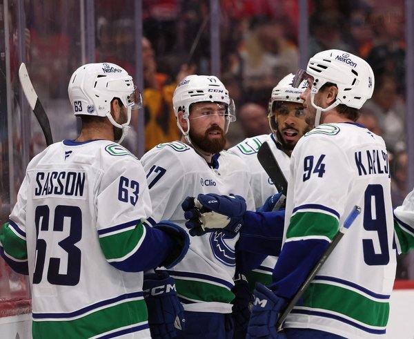 Filip Hronek se raduje se spoluhráči z gólu