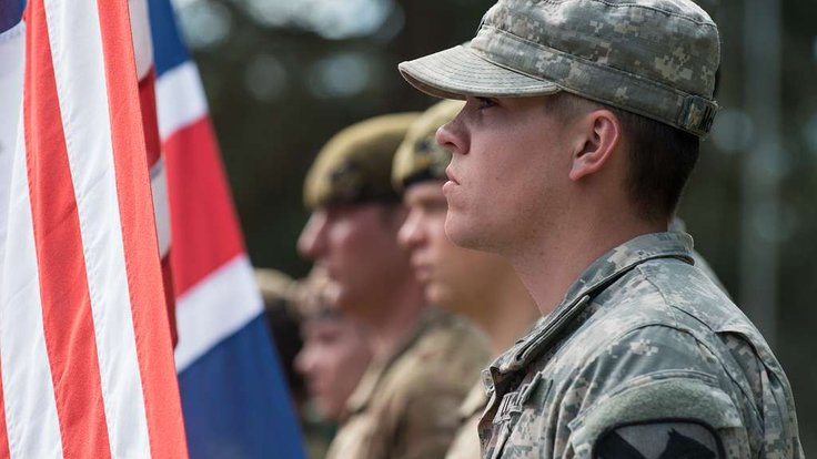 a-us-army-soldier-stands-ready-to-raise-the-american-3b48a2