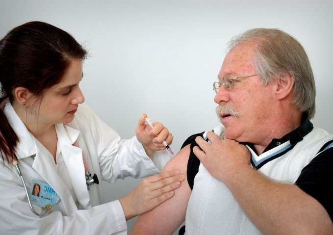 middle-aged-man-receiving-an-intramuscular-immunization-into-his-left-shoulder-muscle-from-a-female-nurse-725x479