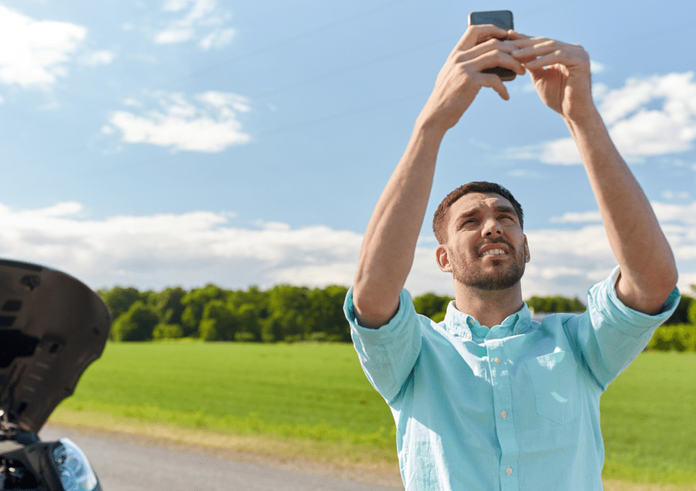 person-tries-to-get-a-cell-signal-while-on-the-road