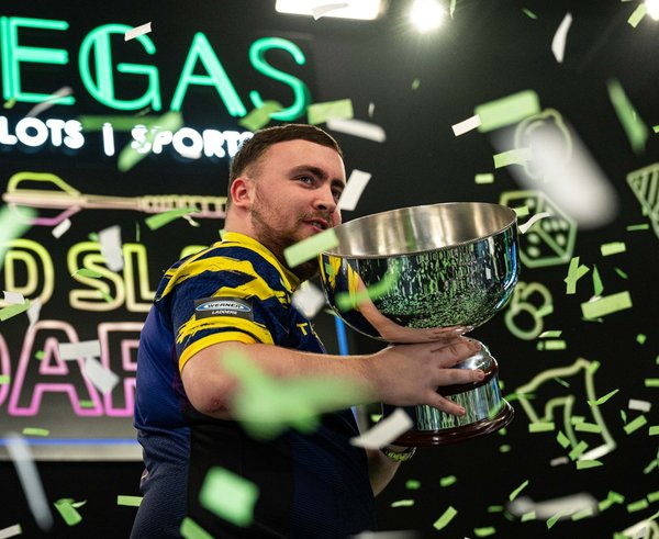 Luke Littler s vítěznou trofejí.