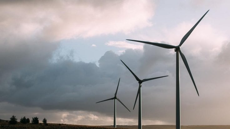 three-wind-turbines-standing-on-a-grassy-landscape